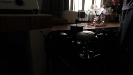 close-up view of young man grabbing glass carafe on coffee cart to prepare coffee pour-over in apartment - static shot