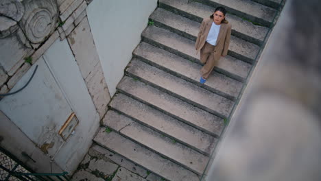 woman tourist walking downstairs exploring old town area alone. carefree lady