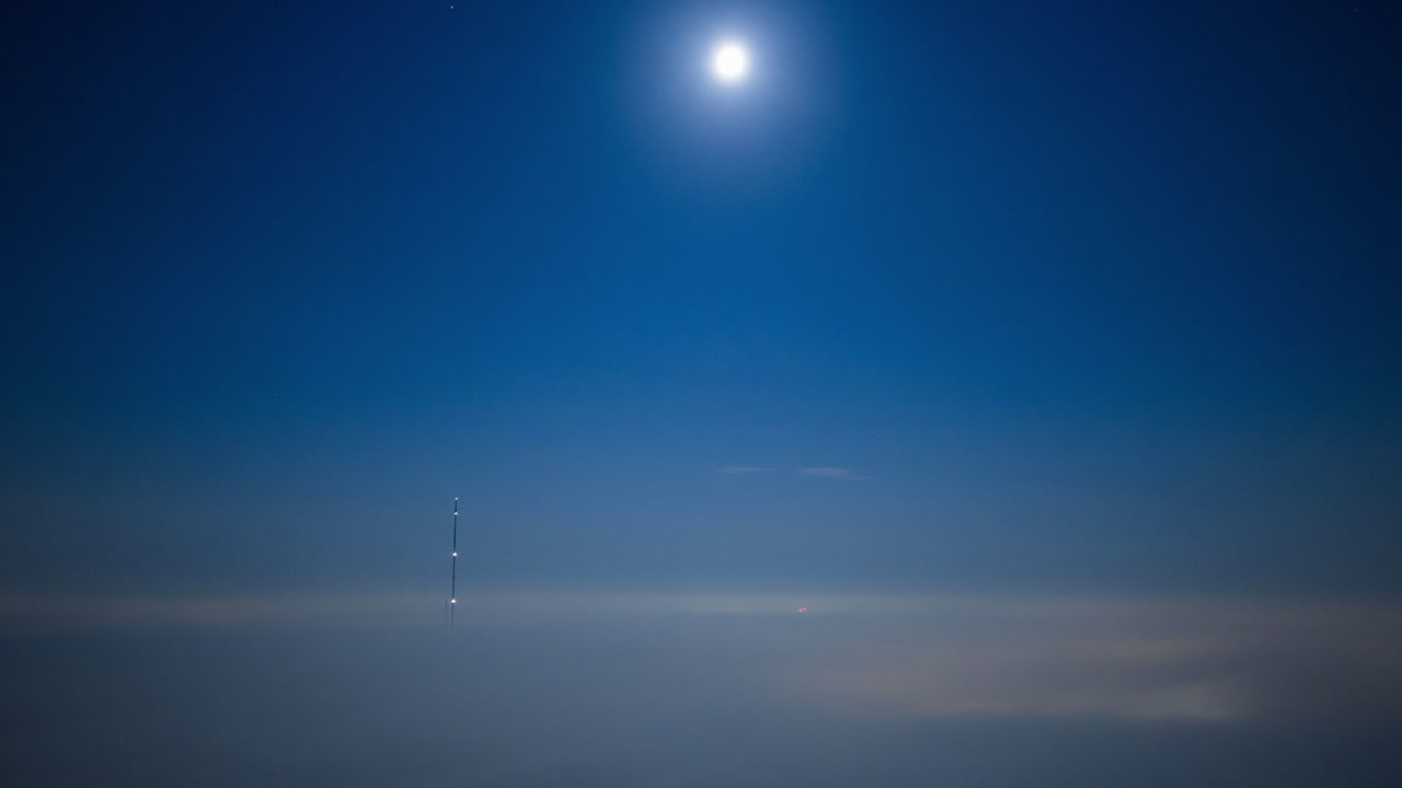 Night scene with moon and fog over radio tower