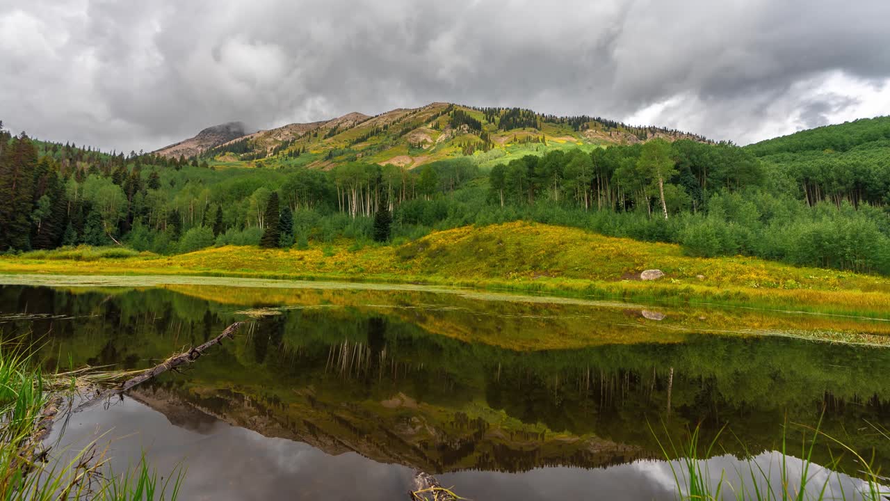 Time Lapse of Clouds and Green Mountain Landscape Reflection on Alpine Lake. Crested Butte, Colorado USA