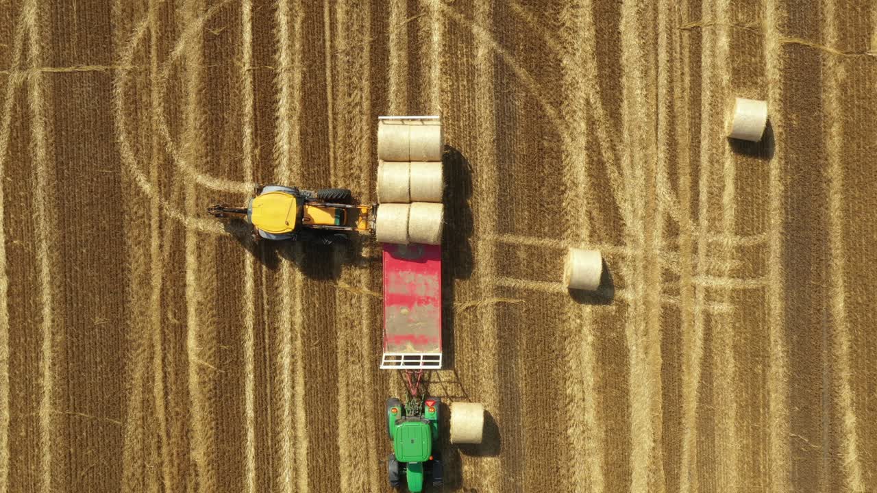 Vista dall'alto di un campo agricolo, con raccolta di balle di paglia rotonde.