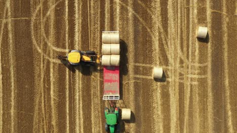 above view of agricultural field, collecting round bales of straw