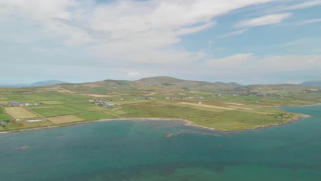 Largo-Video-Aéreo-De-Barrido-De-La-Isla-De-Valentia,-Co-Kerry,-Hogar-Del-Primer-Cable-De-Comunicaciones-Transatlántico-Que-Conecta-Europa-Con-América-Del-Norte,-El-Video-Descansa-Con-Portmagee-En-Primer-Plano