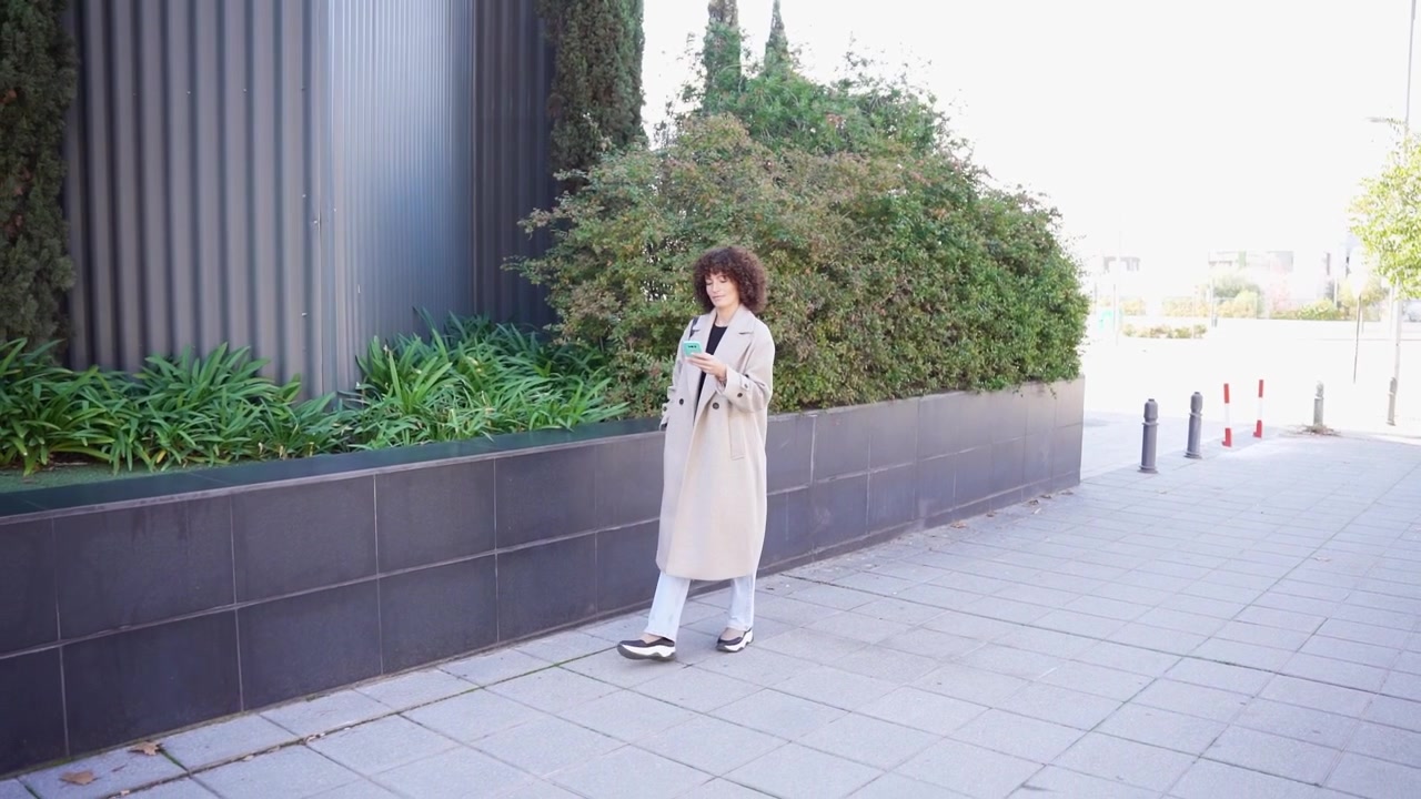鮮やかな都会の緑の中で、スタイリッシュな秋の装いが季節の美しさを際立たせています。
