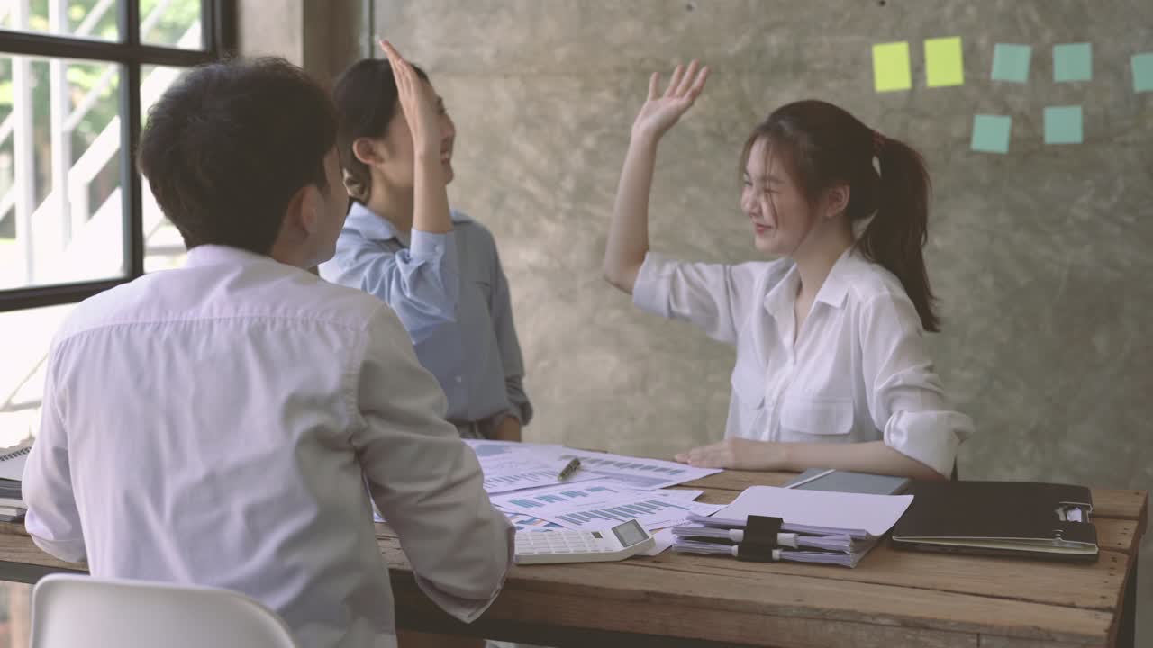 행복한 성공한 아시아 비즈니스 팀은 테이블에 앉아서 다채로운 임원 그룹을 동기 부여하여 팀 빌딩에 참여합니다.