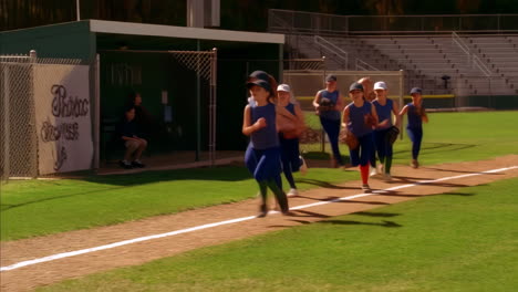 young girls' softball team running on the field during practice