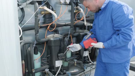 el técnico repara los sensores electrónicos de temperatura con un soldador electrónico