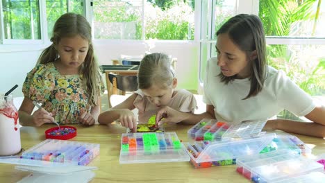 mother and daughters making pixel bead art together