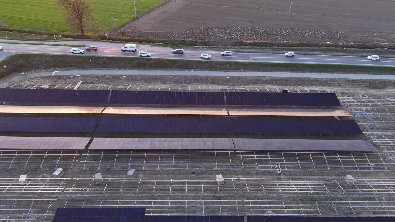 Trwa budowa wielkoskalowej farmy słonecznej na gruntach rolnych, instalowanie paneli fotowoltaicznych dla produkcji energii odnawialnej i zrównoważonego rozwoju energetycznego.