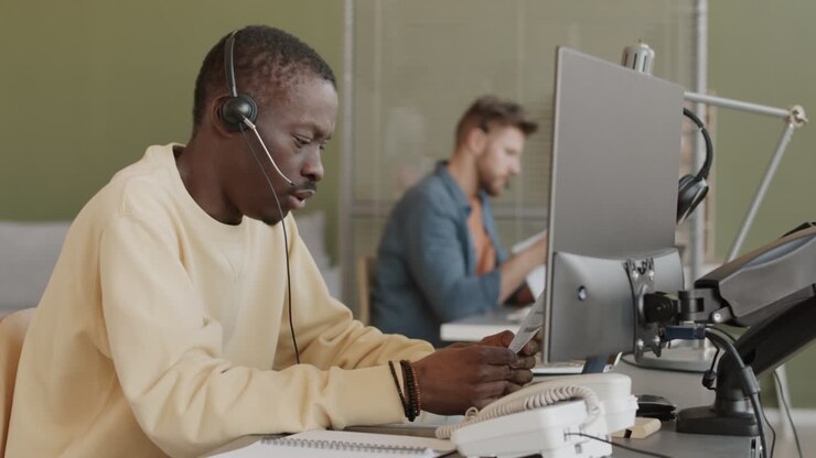 African American Male Trader in Headset Speaking to Investors