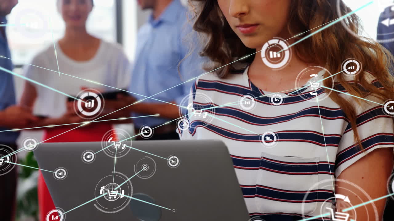 animación de una red de iconos digitales contra una mujer caucásica que usa una computadora portátil en la oficina