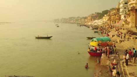 el lapso de tiempo de los peregrinos indios remando en un barco al amanecer. río ganges en varanasi, india.
