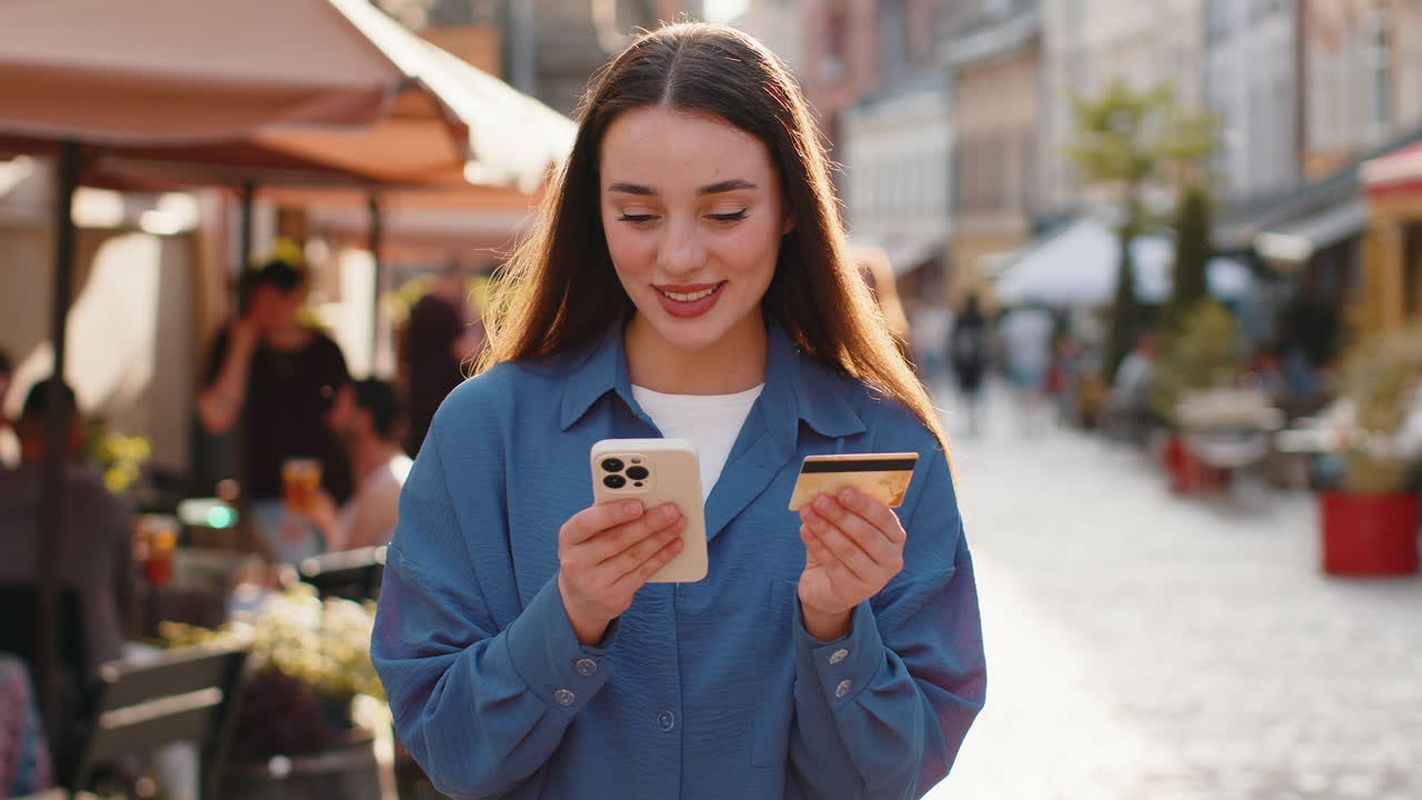 Young woman using credit bank card smartphone while transferring money purchases online shopping