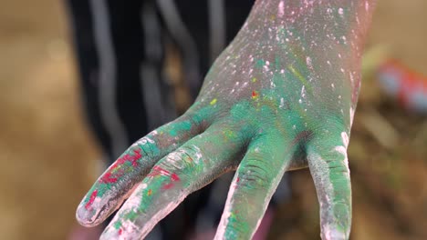 imágenes de colores de holi en la mano humana. niño pequeño disfrutando de holi o festival de dhulandi con gulaal de hierbas.