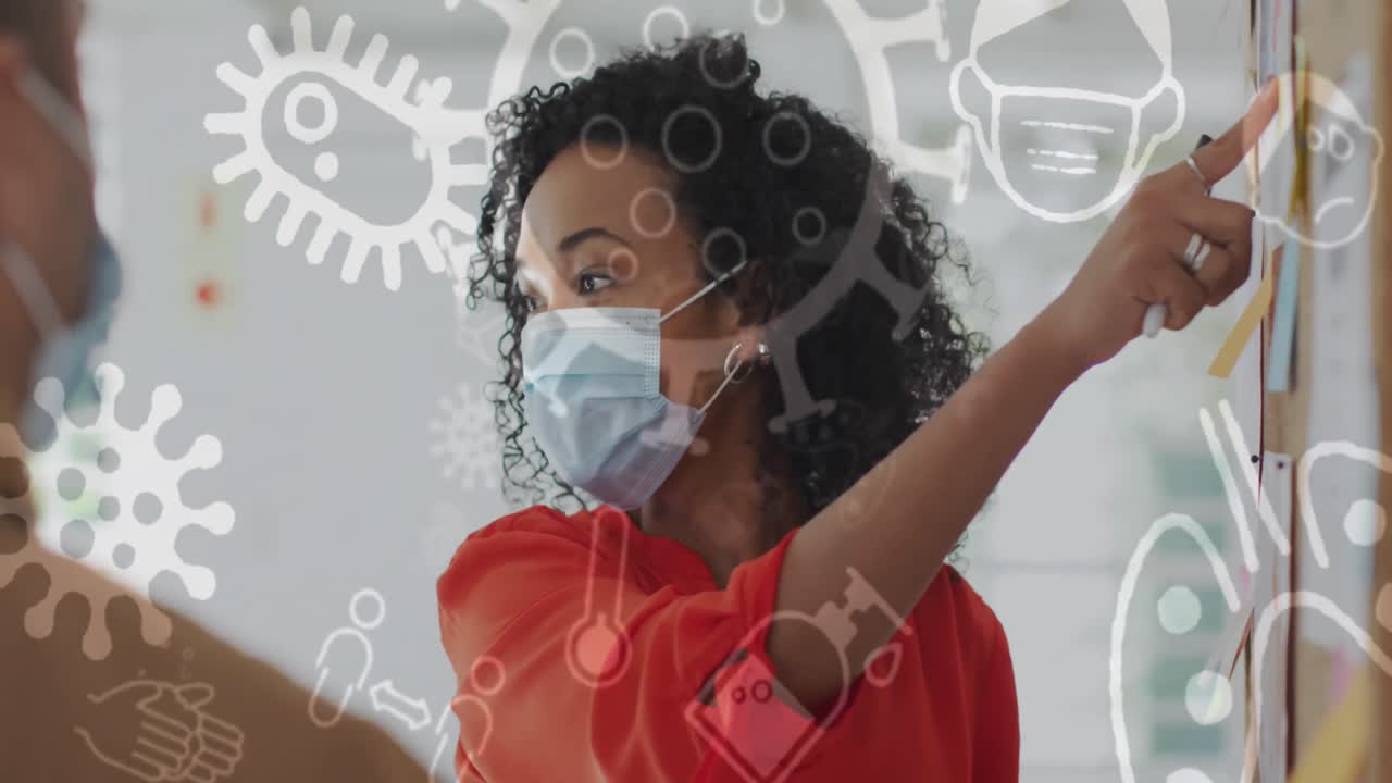Animation of floating covid-19 icons with colleagues in office wearing face masks