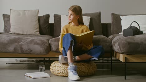 girl reading a book on a sofa