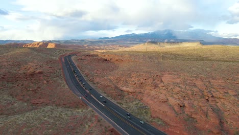 Coches-Circulando-Por-Una-Carretera-Interestatal-15-De-Ashpalt-Negro-De-Dos-Líneas-De-Ancho,-El-Cañón-Rojo-Cerca-De-San-Jorge-En-Un-Día-Soleado-Parcialmente-Nublado