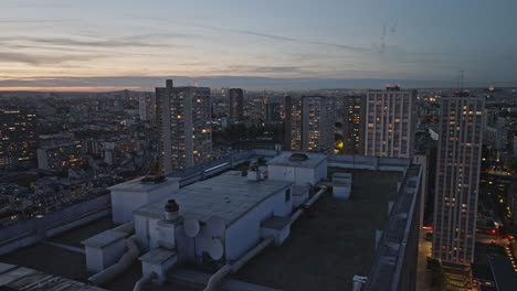 Nighttime-drone-footage-capturing-iconic-Olympiades-landmarks,-brightly-lit-and