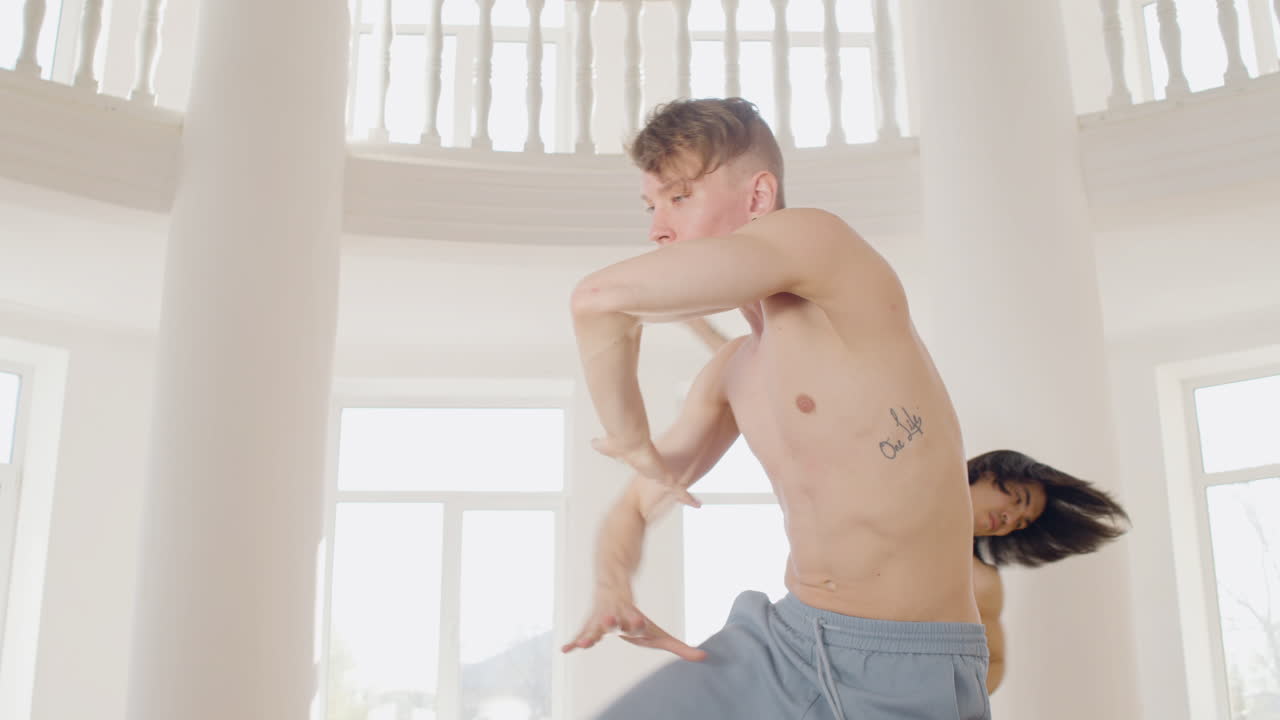 스튜디오 1 한가운데서 댄스 동작을 훈련하는 현대 남성 무용수의 클로즈업 보기