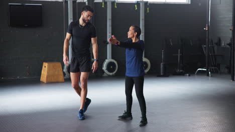 personal trainer assisting client with squat exercise