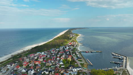 Vista-Aérea-De-Kuźnica,-Un-Pintoresco-Pueblo-En-La-Península-De-Hel-En-Polonia,-Que-Muestra-La-Geografía-única-Con-Casas-Ubicadas-Entre-El-Mar-Báltico-Y-Las-Aguas-De-La-Bahía.