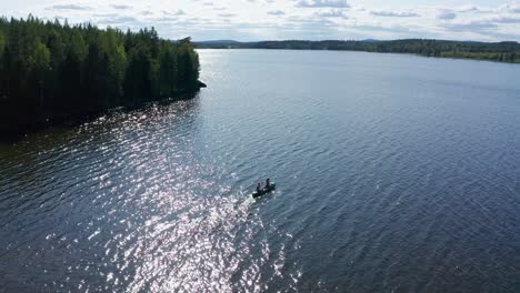 Tiro-De-Drone-De-Un-Lago-Cristalino-En-El-Interior-De-Suecia-Con-Canoa