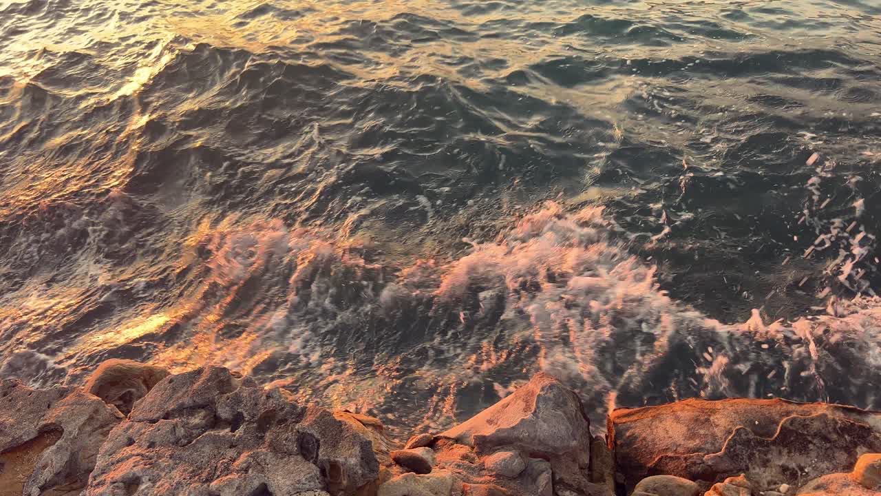 clip de agua con olas, mar, océano, río, lago o laguna con viento golpeando las rocas en la costa.