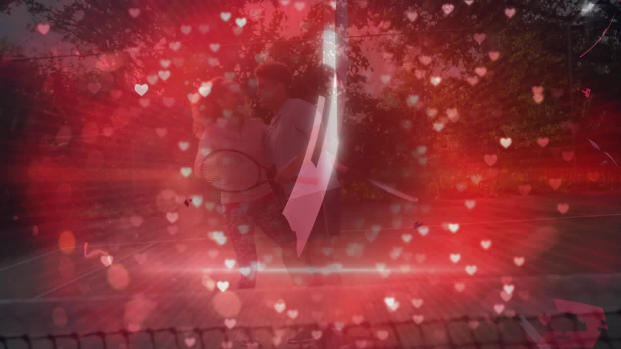 Cuore rosso rotante che si spezza e si frantuma, rivelando una coppia su un campo da tennis che si abbraccia per la salute.