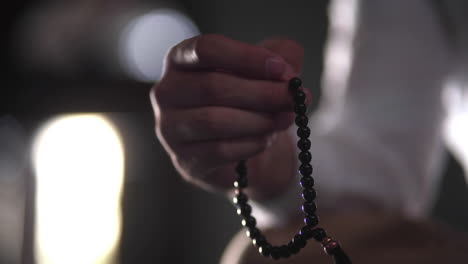 hand of muslim man making zikr using rosary