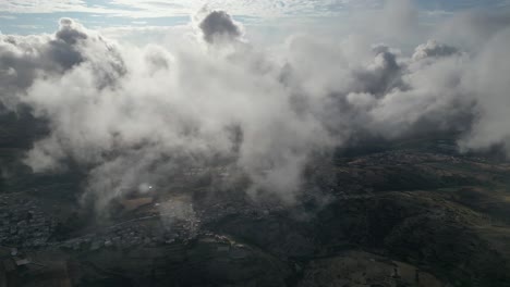 spectacular aerial view between white clouds above charming, peaceful small towns