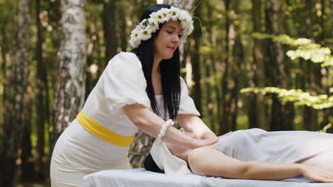 terapeuta donna medico che fa donna rilassante spa massaggio del viso con le mani all'aperto nella foresta