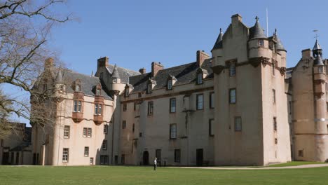 el caminante pasa frente a la elevación lateral del castillo de fyvie en una hermosa mañana de primavera