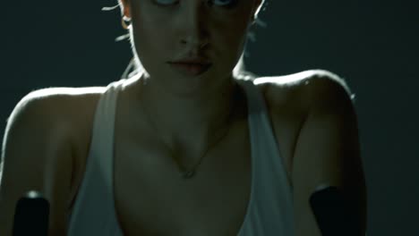 vertical tracking shot starting at a woman’s feet pedaling, moving smoothly upward along her legs, hips, hands on the handlebar, and finally to her focused face, all in cinematic lighting and rhythm