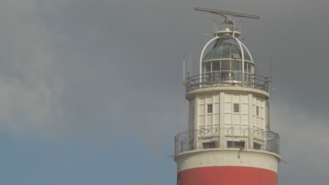 close-up view of a red and white lighthouse against a cloudy sky