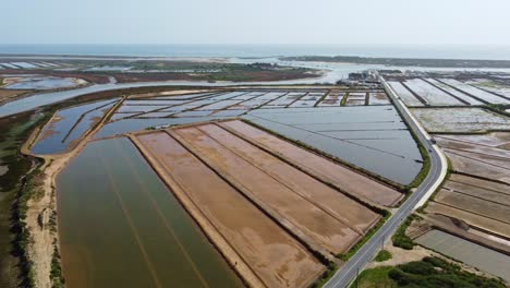 The-road-to-the-sea,-Tavira-Portugal-salt-lagoons-and-nature-reserve-with-the-Atlantic-Sea-behind