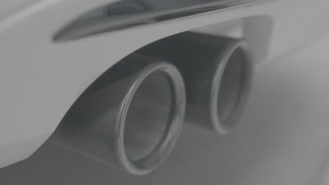 Closeup-shot-of-a-white-car-exhaust-moving-when-started-and-shaking-in-slowmotion-LOG