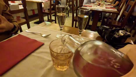 person pouring water into a glass