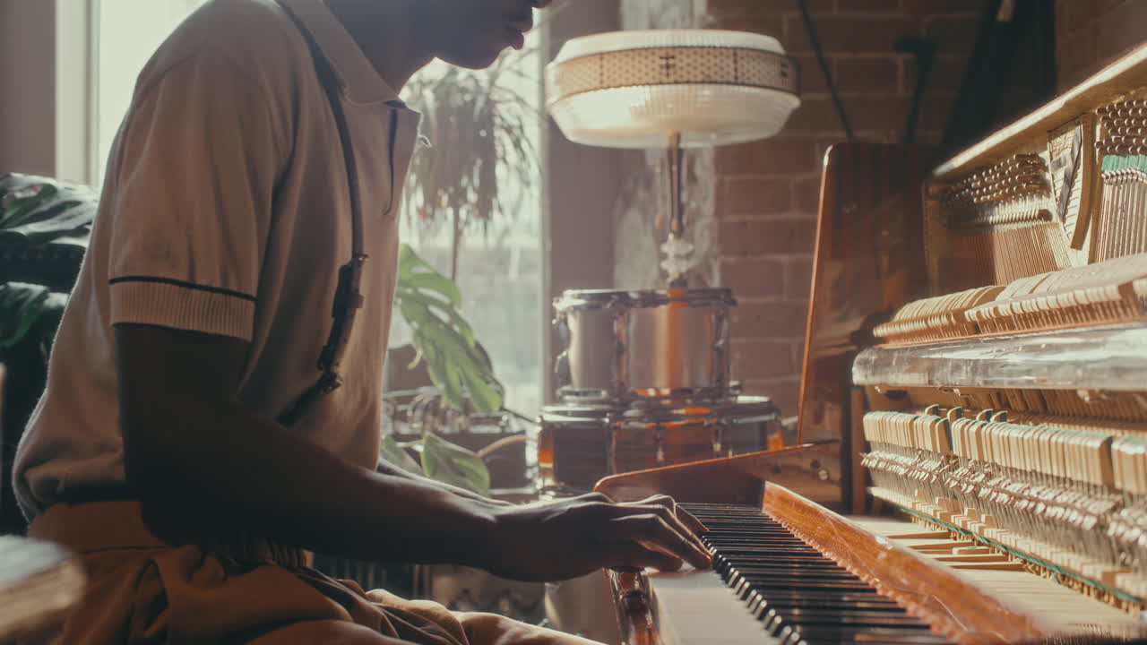 Man Playing Vintage Piano in a Cozy Studio