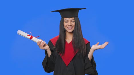 retrato de una estudiante en traje de graduación de gorra y túnica, sosteniendo su diploma, suspira con alivio y sonríe. joven posando en el fondo de la pantalla azul. primer plano. cámara lenta lista 59.94fps