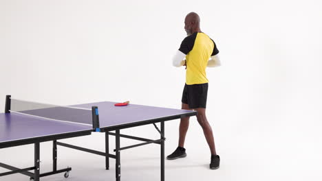 playing table tennis, african american man in sportswear standing by table with paddle