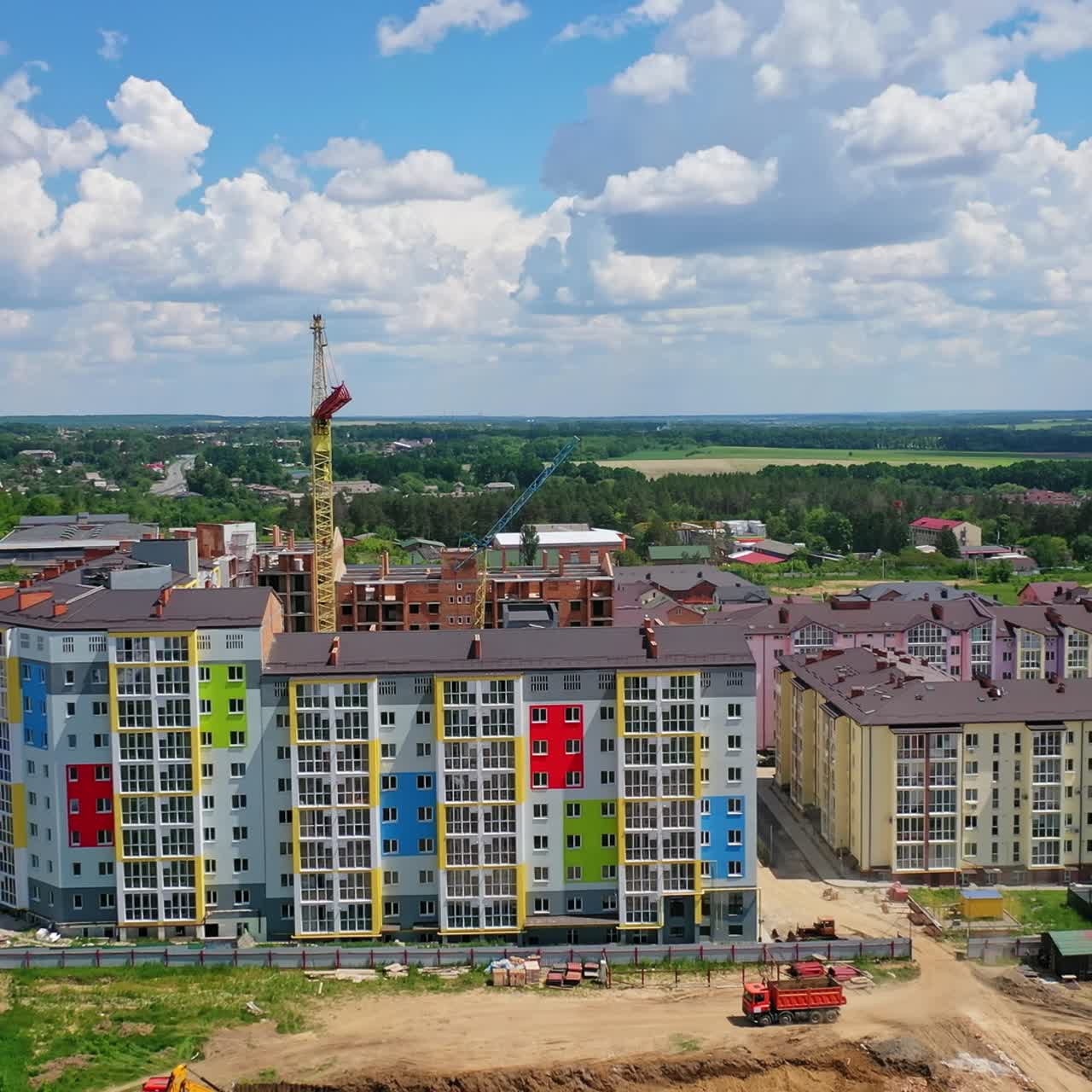 Modern urban district building in the construction site. Front view of a modern newly built high rise apartment. Drone view. Motion camera back