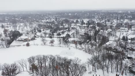 Aerial,-people-skating-on-outdoor-ice-rink-on-frozen-lake-during-winter