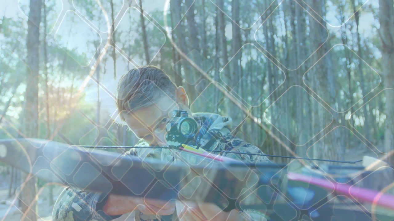 Man wearing camouflage jacket aiming modern crossbow in forest, showing technology grid overlay