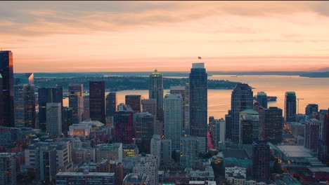 pacific northwest cityscape aerial view in between skyscrapers orange sunset sky seattle washington usa downtown towers western waterfront coastline puget sound background