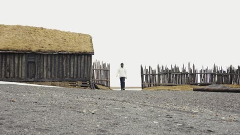 hombre entrando en el pueblo vikingo, atracción turística de islandia 50fps