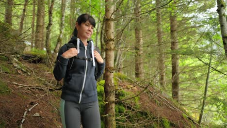 hiking woman walk with a hiking backpack in spring green forest