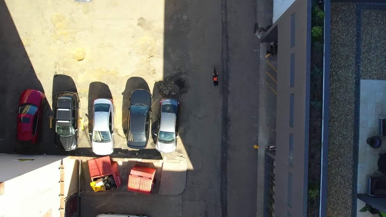 도시 의 쇼핑몰 근처 의 사이드 스트리트 에서 자전거 를 타고 있는 드론 추적