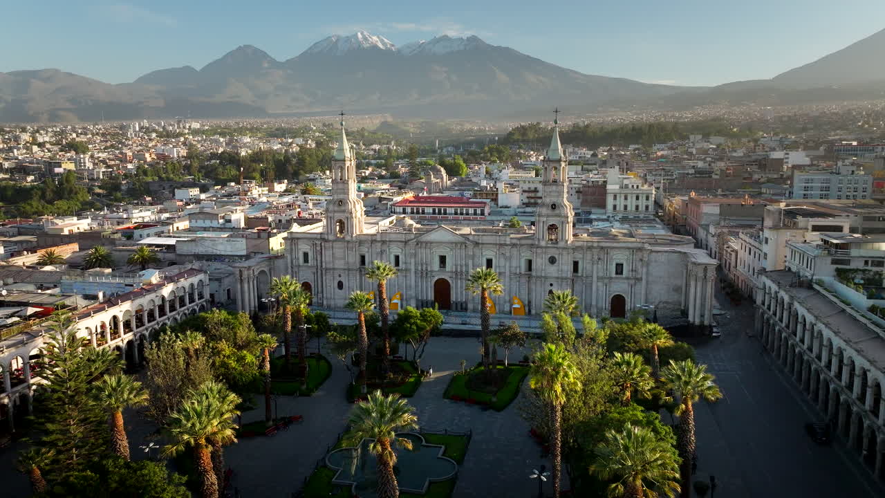 Vista de dron de la histórica Basílica Catedral de Arequipa en la Plaza de Armas, con el volcán Misti al fondo, Perú. Imágenes aéreas frontales.