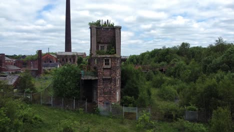 abandoned chatterley whitfield overgrown coal mine industrial museum buildings aerial view low orbit left