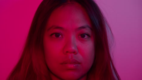close-up portrait of a young woman with red lighting